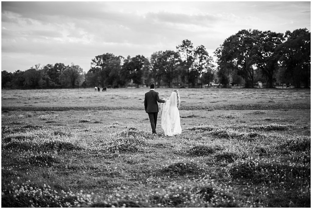 Bride and groom in field | By Jacksonville Wedding Photographer, Nikki Golden