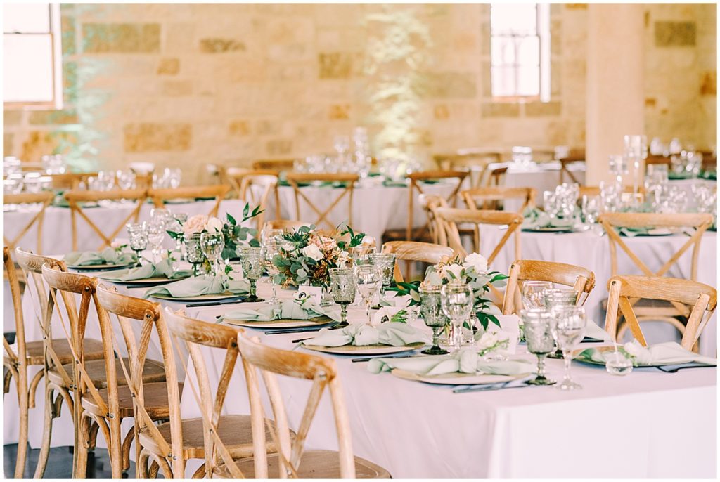 Wedding reception tables with sage green, light pink, and grey floral details