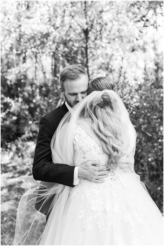 Black and white photo of bride and groom hugging