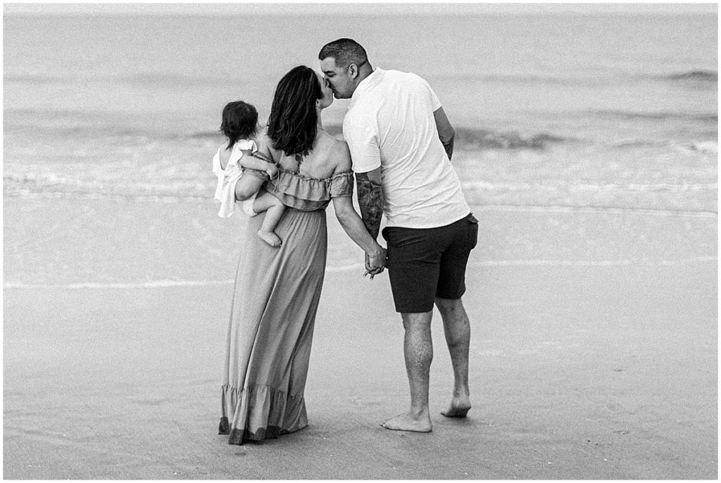 Black and white image of couple with baby daughter on the beach | By St Augustine Photographer, Nikki Golden