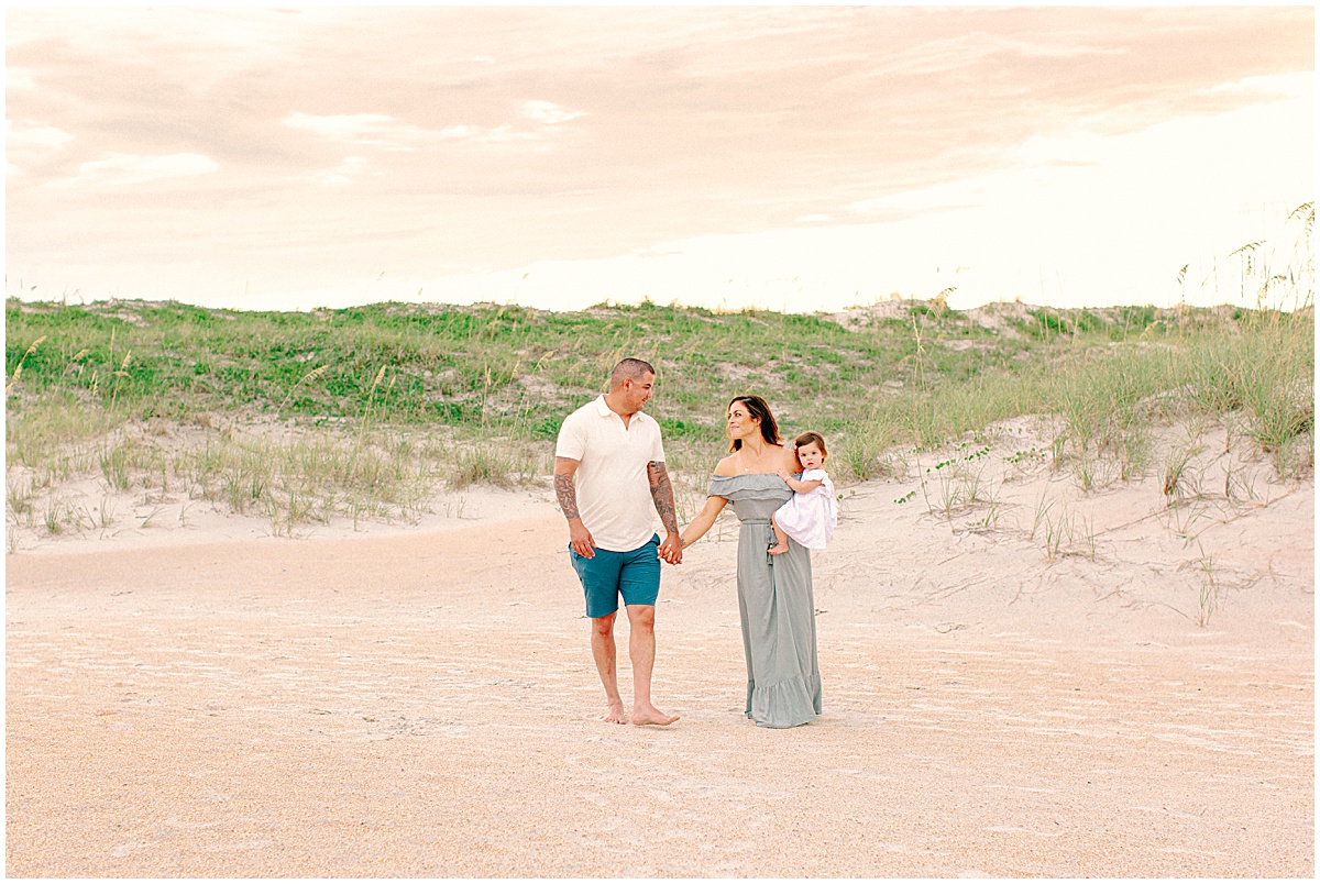 Couple walking on beach in St Augustine with baby girl