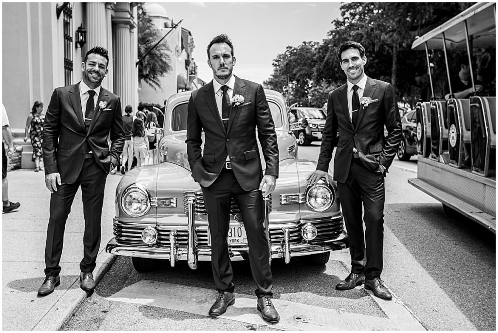 Groom with groomsmen in vintage wedding car
