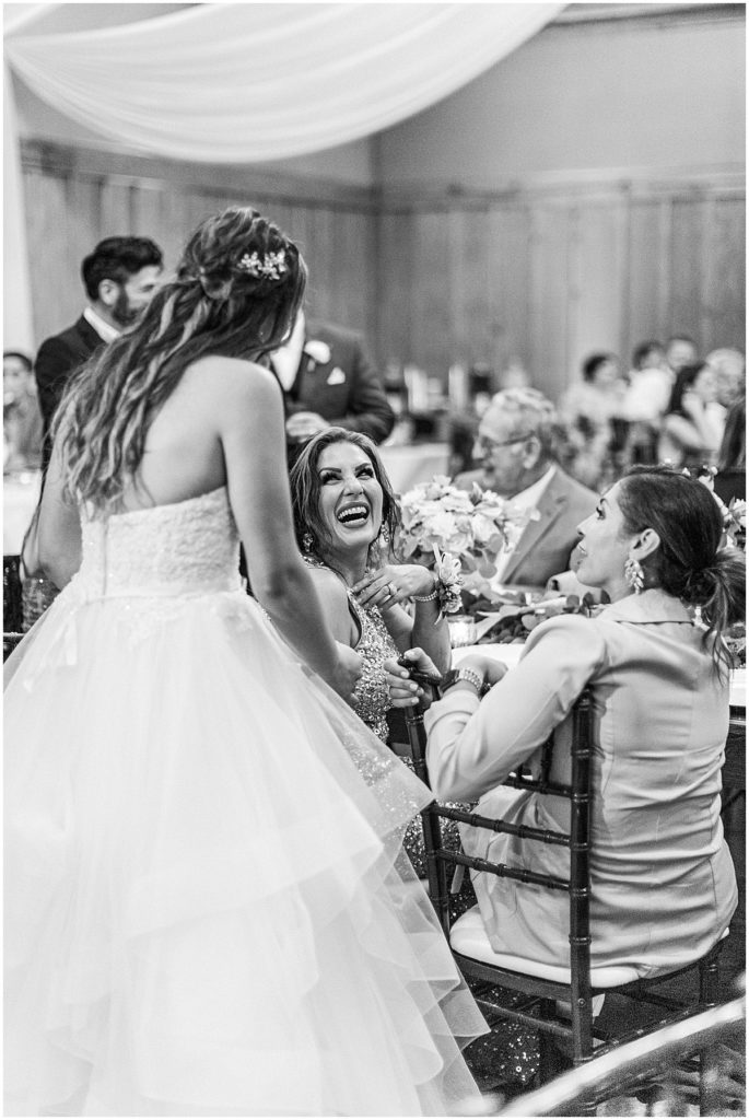 Black and white image of bride chatting with guests