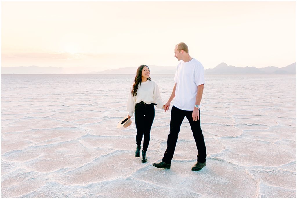 Couple walking along holding hands at the salt flats in Utah | Destination wedding photographer | Nikki Golden