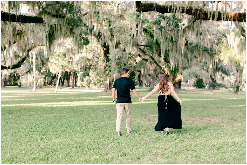 Couple holding hands beneath the trees at Jekyll Island Engagement session by Jekyll Island wedding photographer.