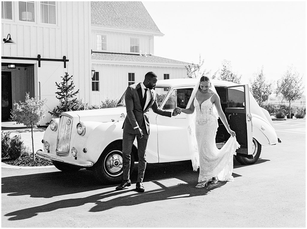 black and white images of groom holding brides hand outside white wedding car, at River Bottoms Ranch, Utah | Nikki Golden Photography