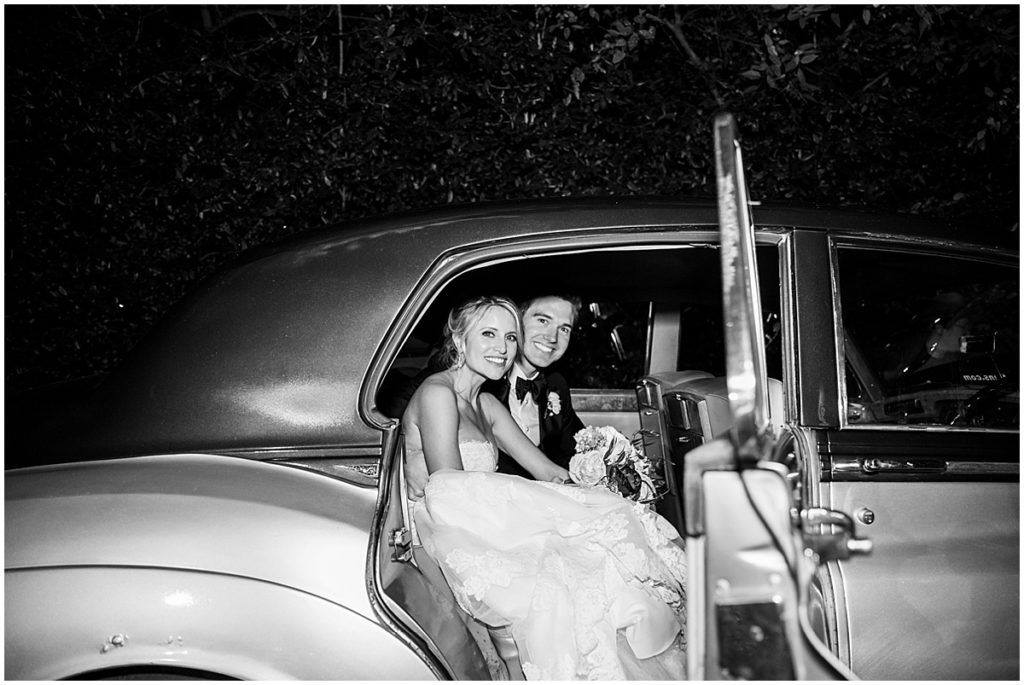Black and white image of bride and groom's wedding exit car. The wedding reception was held at The Estate, Atlanta. Nikki Golden Photography