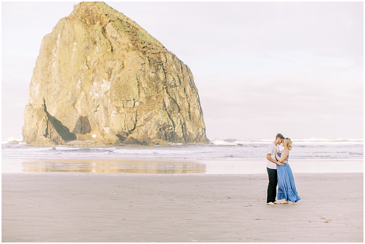 Couples session at Cannon Beach, Oregon with Haystack Rock in the background | Photography by Nikki Golden Photography