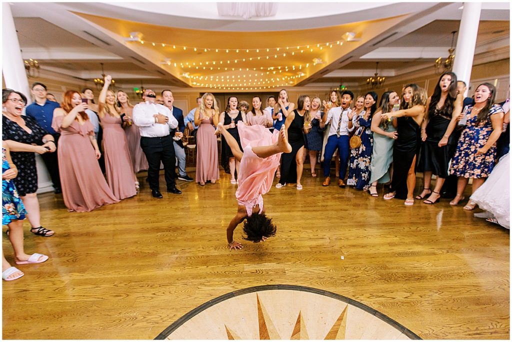 Bridesmaid performing gymnastics moves in the center of the dance floor at wedding reception | Nikki Golden Photography 