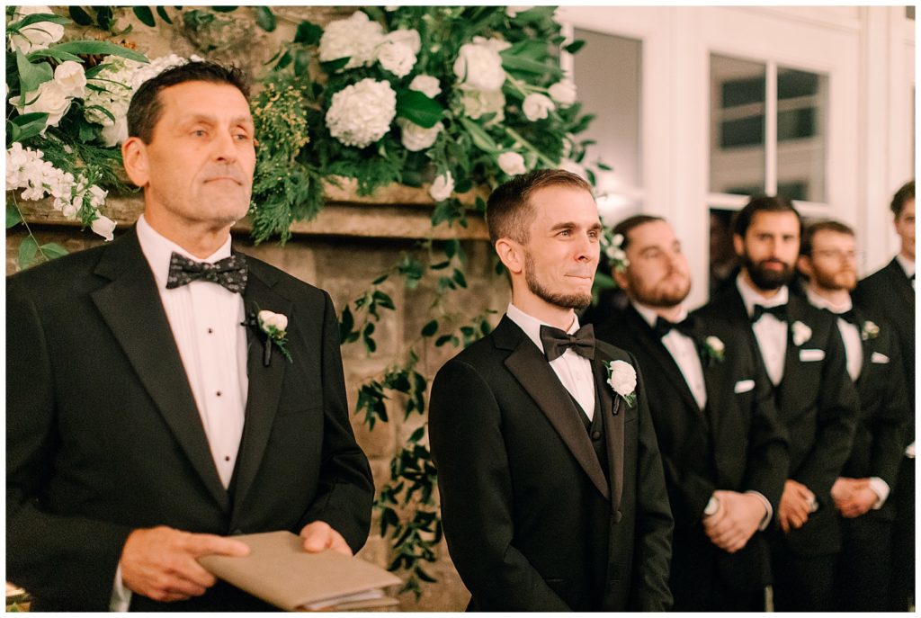 groom reacting to his bride walking down the aisle
