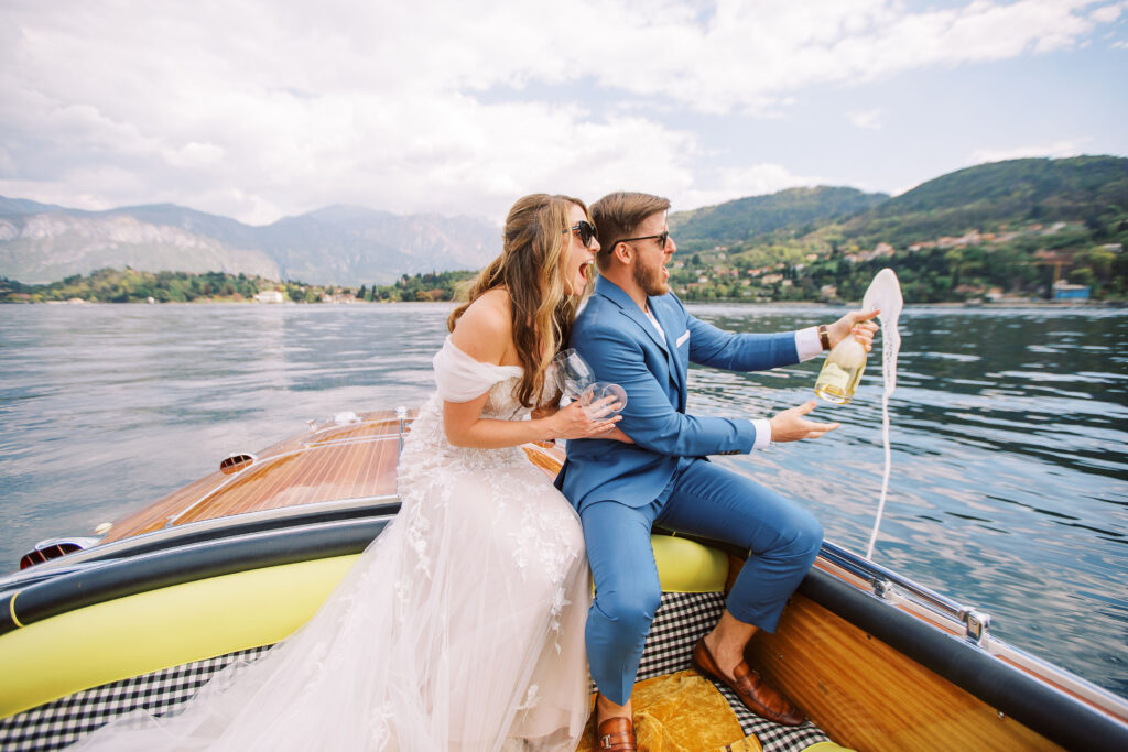 Bride and groom popping champagne on a boat in lake como italy