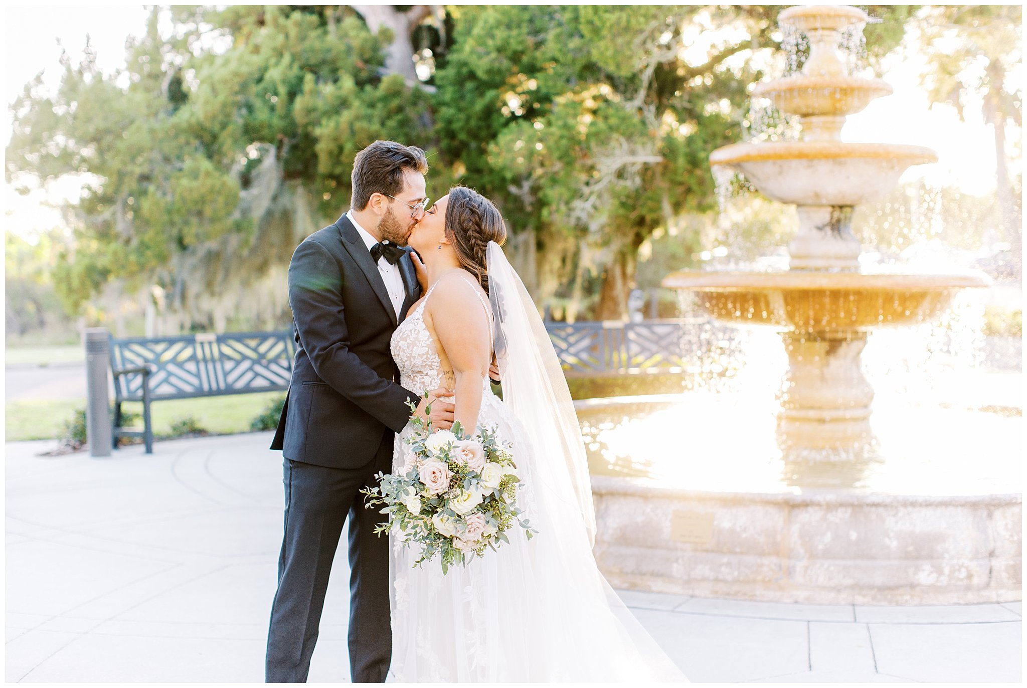 Bride and groom kissing in front of a fountain