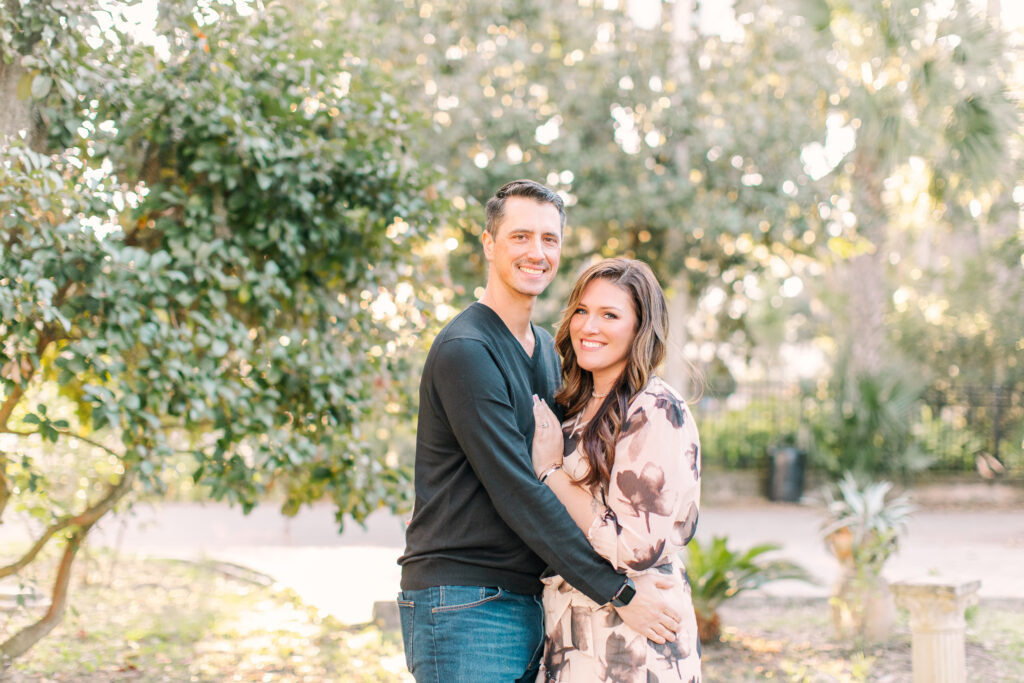 couple in front of a greenery background looking at the camera