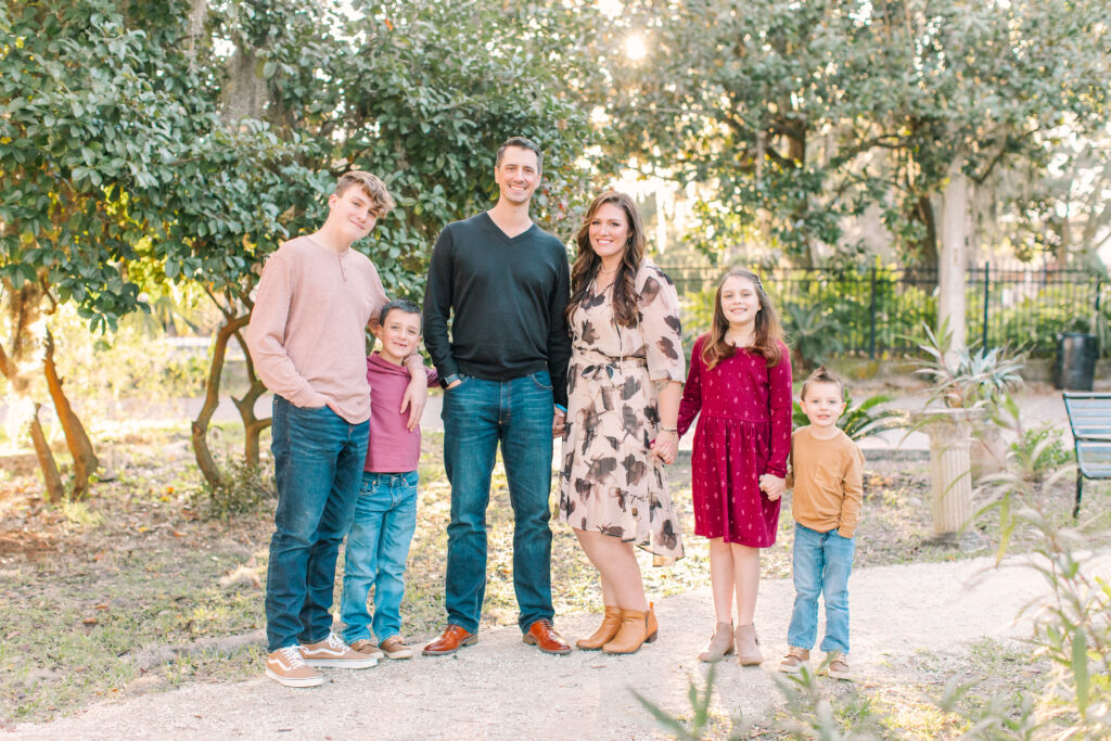 family of six in front of a greenery background looking at the camera