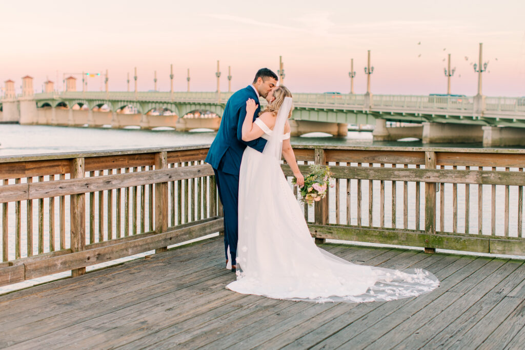 bride and groom on a dock in front of a long bride in St Augustine FL