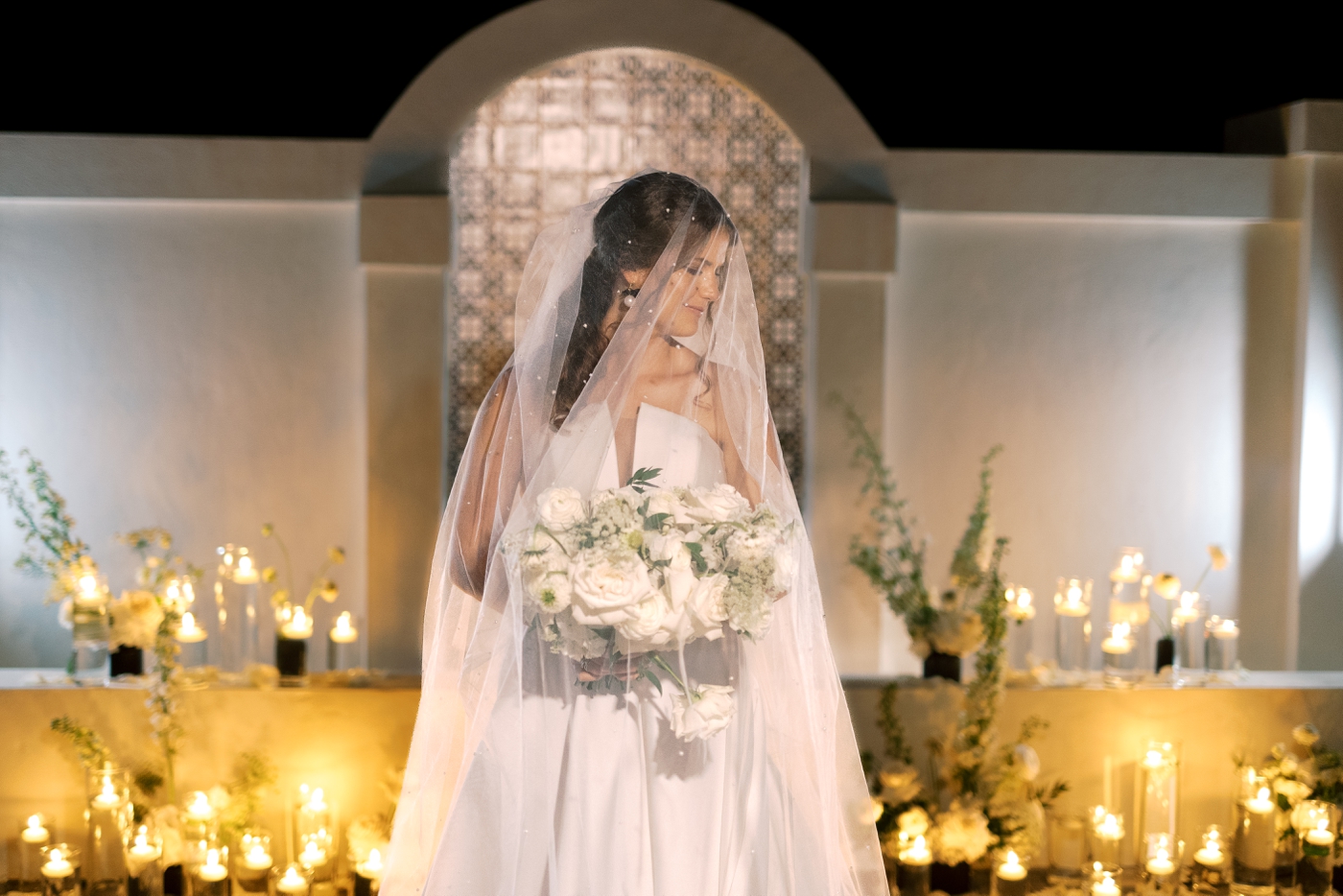 Bride in the courtyard at Old Spanish Quarter, surrounded by hundreds of candles and white flowers 