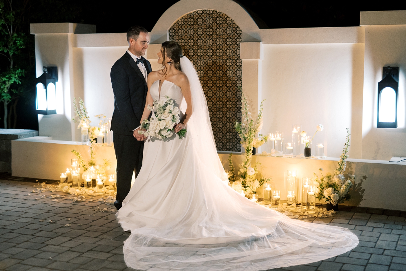 Couple embracing at their wedding table for an evening wedding in Jacksonville, photographed by Nikki Golden