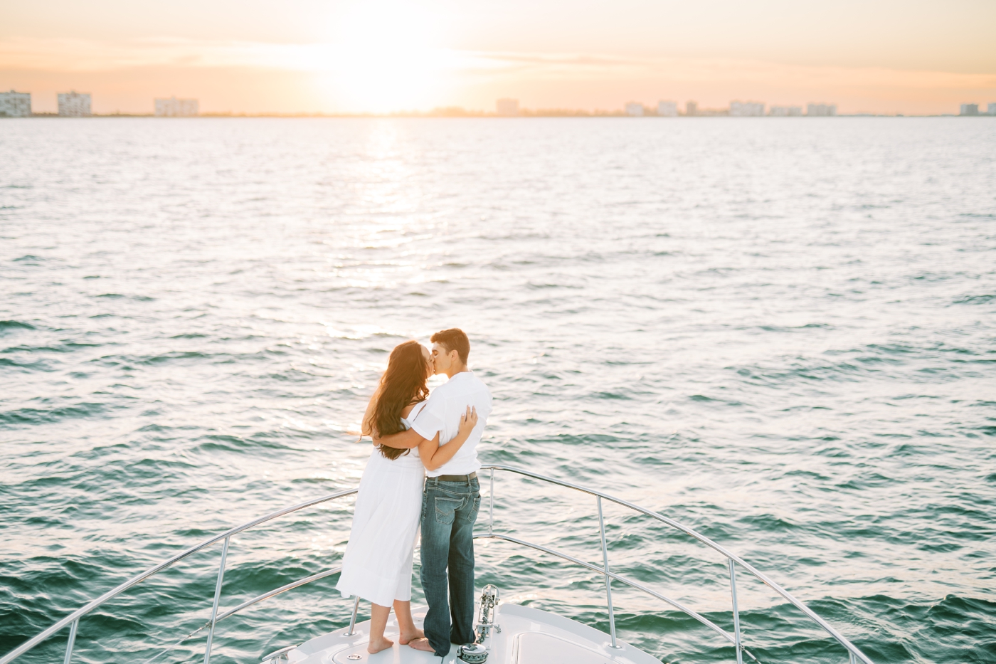 Proposal on a private boat tour in St Augustine, with the sun setting behind the couple sitting on the bow