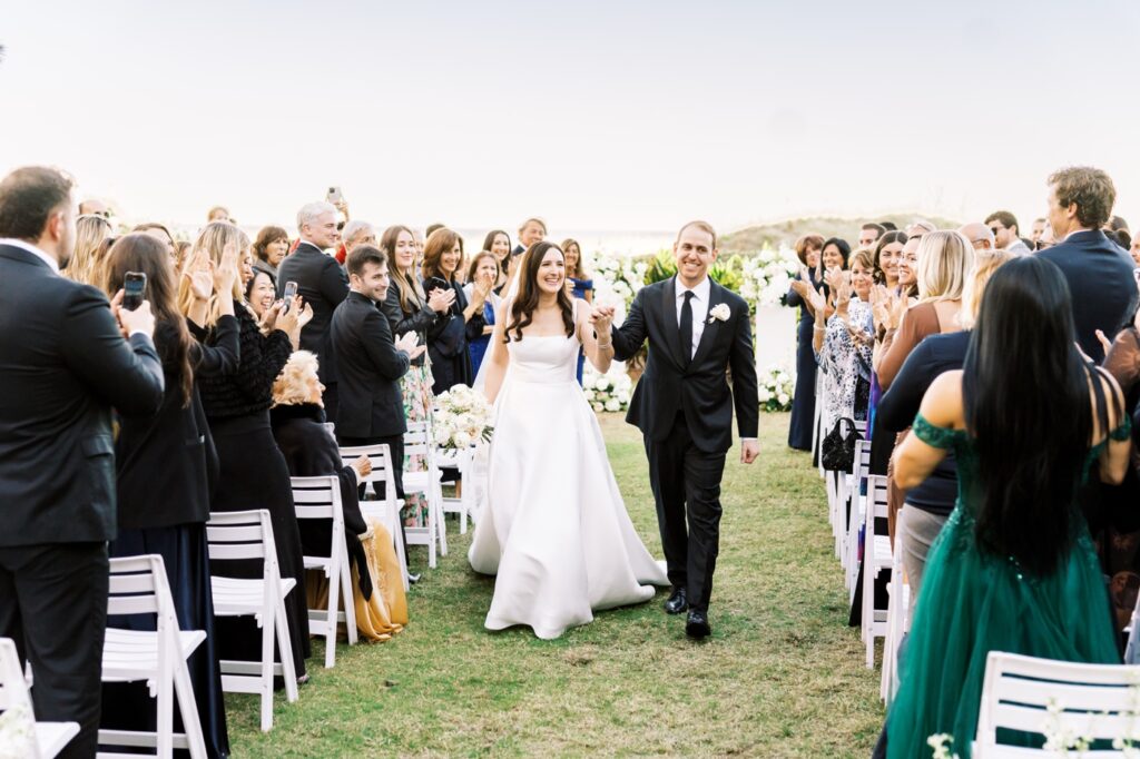 Bride and Groom recessing down the aisle after their wedding ceremony hand in hand 